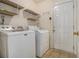 This laundry room includes white washer and dryer with wire shelving for storage space at 1698 Bennett Dr, Mcdonough, GA 30253