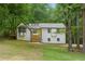 Charming two-story home with a bright yellow door and a large front yard surrounded by lush trees at 3713 Brigantine Ct, Acworth, GA 30102
