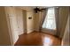 Cozy bedroom with hardwood floors, neutral walls, closet, and a sunlit window with curtains and ceiling fan at 57 Forsyth Nw St # 11B, Atlanta, GA 30303