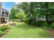 Backyard with lush green lawn, stone patio, fire pit, and screened-in porch at 2260 Falkirk Pointe Dr, Marietta, GA 30062