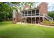 Back exterior view of a brick house featuring a screened porch, patio, and spacious yard at 2260 Falkirk Pointe Dr, Marietta, GA 30062