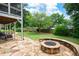 Beautiful backyard with stone patio, built-in fire pit, and lush landscaping at 2260 Falkirk Pointe Dr, Marietta, GA 30062