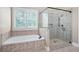 Elegant bathroom featuring a soaking tub, a separate shower, and tiled walls at 2260 Falkirk Pointe Dr, Marietta, GA 30062