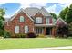 Charming red brick home with a well-manicured lawn, gray shutters, and a welcoming front porch at 2260 Falkirk Pointe Dr, Marietta, GA 30062