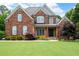 Beautiful two-story red brick home with a lush green lawn and symmetrical landscaping at 2260 Falkirk Pointe Dr, Marietta, GA 30062