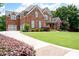 Spacious home featuring a brick exterior, large driveway, and meticulously maintained front lawn and landscaping at 2260 Falkirk Pointe Dr, Marietta, GA 30062