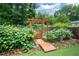 Well-maintained backyard vegetable garden and wooden bridge with mature plants at 2260 Falkirk Pointe Dr, Marietta, GA 30062