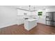 Bright, open kitchen with an island, stainless steel appliances, white cabinets, and stone countertops at 401 Cottonwood Dr, Woodstock, GA 30189