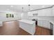 Bright kitchen features white cabinets, stainless appliances, and an island with a quartz countertop at 401 Cottonwood Dr, Woodstock, GA 30189