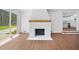 Living room featuring a white brick fireplace with a wooden mantle and access to the kitchen at 401 Cottonwood Dr, Woodstock, GA 30189