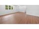 Spacious living room offering pristine white walls, a new front door, and warm new wood floors at 401 Cottonwood Dr, Woodstock, GA 30189