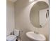 Powder room featuring a pedestal sink and oval mirror at 4405 Donahue Ave, Sugar Hill, GA 30518