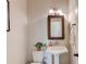 Cozy powder room featuring a pedestal sink, framed mirror, and neutral decor at 4405 Donahue Ave, Sugar Hill, GA 30518