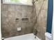 A shower/tub combo features neutral tile and updated fixtures and trim at 4635 Tims Pl, Snellville, GA 30039