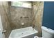 Bathroom featuring tiled walls, bathtub, shower head, and white toilet at 4635 Tims Pl, Snellville, GA 30039
