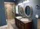 Stylish bathroom featuring dual sinks, granite countertops, and a glass-enclosed shower at 4635 Tims Pl, Snellville, GA 30039