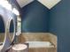 Bathroom with dual sinks, tile accents, tub, and modern fixtures under vaulted ceilings at 4635 Tims Pl, Snellville, GA 30039
