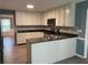 Well-lit kitchen featuring white cabinets, granite countertops, stainless steel appliances, and wood-look flooring at 4635 Tims Pl, Snellville, GA 30039