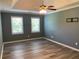 Main bedroom features updated flooring, a tray ceiling, a ceiling fan, and two windows for ample natural light at 4635 Tims Pl, Snellville, GA 30039