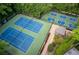 Aerial view of tennis courts surrounded by tall trees at 1001 Braelin Ct, Woodstock, GA 30189