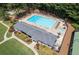 Aerial view of the community pool, clubhouse, and tennis court surrounded by trees at 1001 Braelin Ct, Woodstock, GA 30189