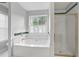 Bathroom with a relaxing soaking tub and a glass enclosed shower at 1001 Braelin Ct, Woodstock, GA 30189