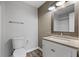 Well-lit bathroom featuring a vanity, mirror, textured wallpaper, and a toilet at 1001 Braelin Ct, Woodstock, GA 30189