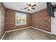 Cozy bedroom with red brick accent wall, ceiling fan, and natural light at 1001 Braelin Ct, Woodstock, GA 30189