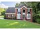 Charming two-story brick home with manicured lawn and dark shutters at 1001 Braelin Ct, Woodstock, GA 30189