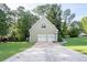 Two-car garage with a basketball hoop, set against a backdrop of lush greenery at 1001 Braelin Ct, Woodstock, GA 30189