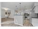 Open-concept living space connecting the kitchen and living areas, with hardwood floors and modern lighting at 1001 Braelin Ct, Woodstock, GA 30189