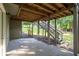 Covered porch with exposed wood beams, offering shade and access to the backyard at 1001 Braelin Ct, Woodstock, GA 30189