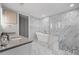 Elegant bathroom featuring marble tiling, a glass shower, and a free-standing tub at 270 17Th Nw St # 2804, Atlanta, GA 30363