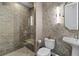 Bathroom featuring textured wall paper, walk-in shower with glass door, and pedestal sink at 270 17Th Nw St # 2804, Atlanta, GA 30363