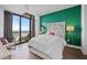 Bedroom with green accent wall, hardwood floors, and floor to ceiling window with city view at 270 17Th Nw St # 2804, Atlanta, GA 30363