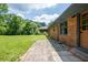 Backyard featuring a brick patio, grassy yard, and mature trees at 3219 W Manor Ln, Atlanta, GA 30311