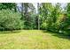Large backyard providing ample space for outdoor activities, surrounded by mature trees for shade and privacy at 3219 W Manor Ln, Atlanta, GA 30311