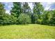 Expansive backyard featuring a lush lawn and mature trees, creating a private outdoor space at 3219 W Manor Ln, Atlanta, GA 30311