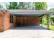 Covered carport adjacent to a brick home with a doorway, offering shelter and convenience at 3219 W Manor Ln, Atlanta, GA 30311