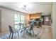 Cozy dining area with a glass table, modern lighting, and open layout to the kitchen at 3219 W Manor Ln, Atlanta, GA 30311