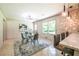 Bright dining room with modern chandelier, glass table, and stylish gray chairs and view to backyard at 3219 W Manor Ln, Atlanta, GA 30311