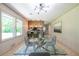Bright dining area with a glass table, modern lighting, and seamless kitchen access at 3219 W Manor Ln, Atlanta, GA 30311