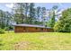 Rear view of a brick home featuring a well-kept lawn and a fenced yard, offering privacy and space at 3219 W Manor Ln, Atlanta, GA 30311
