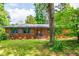 Charming brick home with well-maintained lawn, gray shutters and mature trees providing shade at 3219 W Manor Ln, Atlanta, GA 30311