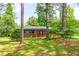 Charming brick home with well-maintained lawn, gray shutters and mature trees providing shade at 3219 W Manor Ln, Atlanta, GA 30311