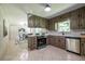 Well-lit kitchen with stainless steel appliances, tile backsplash, and adjoining dining area at 3219 W Manor Ln, Atlanta, GA 30311