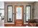 A stylish front door with stained glass, flanked by sidelights, set against a textured wall and wood floors at 3493 Wood Acres Blvd, Duluth, GA 30096
