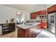 Modern kitchen with a granite-topped island, stainless steel appliances, and cherry wood cabinetry at 3493 Wood Acres Blvd, Duluth, GA 30096
