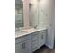 Bathroom featuring double sink vanity, framed mirrors, and modern fixtures at 5522 Cosimo Rd, Fairburn, GA 30213