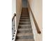 Carpeted staircase with wooden handrails leading to the upper level at 5522 Cosimo Rd, Fairburn, GA 30213